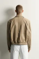 Cazadora relaxed fit de piel con efecto lavado en color tostado, cuello solapa, manga larga con puño y botones a presión. Cuenta con bolsillos plastrón con solapa en la cadera, bolsillo interior y cierre frontal con cremallera oculta por solapa con botones a presión.