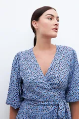 Blusa cruzada celeste con estampado floral, mangas cortas abullonadas y lazo en la cintura.