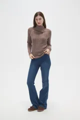 Sweater de punto con diseño de ochos, color camel, con cuello alto y mangas largas.