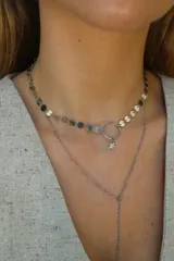 Collar doble plateado, con cadena de eslabones y cadena de círculos. El collar superior tiene un dije de aro con una estrella colgando.