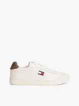 Zapatillas de estilo tenis confeccionadas en piel napa blanca, con diseño de corte bajo y cordones. Presentan un panel a contraste en el talón en color marrón y el parche distintivo de Tommy Jeans en el lateral.