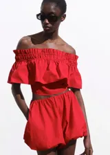 Top crop rojo de algodón, con diseño palabra de honor, escote fruncido elástico y detalle de volante superpuesto en el pecho.