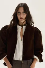 Camisa de pana color chocolate, con corte recto, cuello mao y mangas largas abullonadas con puños ajustados.