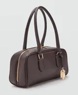 Bolso de mano de poliuretano color marrón oscuro, con diseño rectangular estructurado, cierre de solapa frontal y asa corta de hombro.