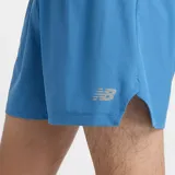 Short de running New Balance RC, color azul claro, con cintura elástica y cordón ajustable. Presenta un slip interior y detalles reflectantes.