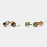 Aros tipo caravana de oro 18k con esmeralda central en corte ovalado rodeada por un halo de brillantes.