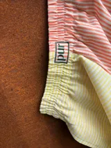 Shorts patchwork con estampado a rayas en tonos pastel (lila, amarillo, celeste y blanco) y detalle de bordado con la palabra 'pur' en verde.