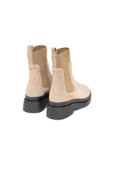 Bota estilo Chelsea de gamuza color avena, con paneles elásticos laterales al tono y suela chunky de goma negra.
