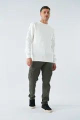 Buzo blanco de algodón con cuello redondo, mangas largas y logo y arte en relieve en el frente.