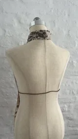 Top halter con estampado animal print de vaca, con tiras finas que se atan en la nuca y en la espalda.