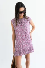 Vestido corto sin mangas en color rosado con estampado floral en blanco y negro. Presenta una cartera de botones asimétrica en el frente y detalle de volado fruncido en el ruedo. Confeccionado en algodón liviano.