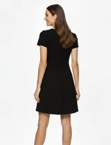 Vestido midi negro con panel frontal de cuero sintético y paneles laterales de tela. De manga corta y escote redondo.