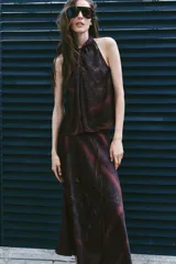 Top halter estampado de color bordó, con cuello alto, diseño sin mangas y cierre posterior con abertura y botón.