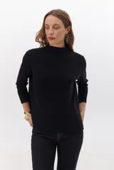Polera de tejido de punto en color beige, con cuello alto y mangas largas con puños acanalados.