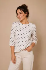 Blusa de algodón con estampado de lunares, cuello redondo y mangas tres cuartos abullonadas con puños elásticos.