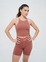 Top deportivo Umbro modelo Kia, color azul marino con detalles en gris en el cuello y sisas. Cuenta con logo estampado en el pecho y diseño de espalda deportiva.