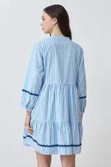 Vestido midi celeste con rayas verticales blancas y cinta ondulada azul marino en escote, mangas y ruedo.