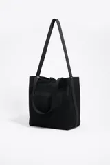 Bolso shopper mediano de hombro Bimba Y Lola confeccionado en tejido Flyknit de estructura blanda y diseño de red. Cuenta con doble asa de mano, asas largas para el hombro, cierre de cordón ajustable y etiqueta frontal con el logo de la marca.