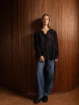 Blusa de tela liviana color bordó, con escote en V y detalles de bordado floral tono sobre tono. Presenta mangas largas con leve volumen y puños abotonados.