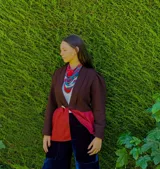 Blazer sastrero de lana y cuero color marrón, con mangas abullonadas, ajuste en la cintura y parte inferior con patrón geométrico en tonos rojos.
