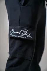 Pantalón de jogging negro con bolsillos cargo laterales y logo estampado en el bolsillo.