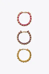 Pack de tres pulseras de tejido a color con aplicación de joyas combinadas a contraste y cierre de mosquetón. Incluye una pulsera fucsia, una púrpura y una amarilla.
