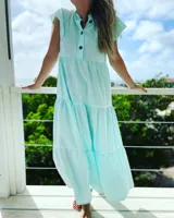 Vestido largo celeste de corte holgado, con cuello mao, mangas cortas y botones frontales.