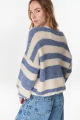 Cardigan tejido de punto a rayas horizontales en tonos crudo y beige, de manga larga y diseño holgado.
