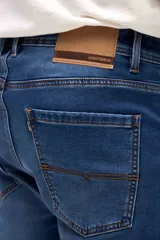 Jean de corte slim, color azul medio, con diseño clásico de cinco bolsillos, cierre frontal con botón y cremallera.