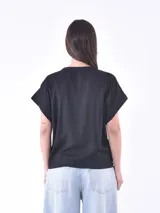 Blusa negra con estampado de ramas en color crema, escote en V y mangas cortas con dobladillo.