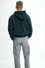 Pantalón cargo de nylon color gris claro, con cintura elástica y cordón ajustable. Presenta bolsillos laterales con cierre, bolsillos cargo con solapa en las piernas y cordón ajustable en los bajos.