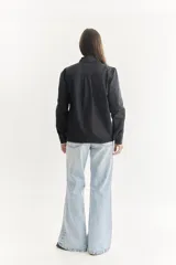 Camisa color beige claro con bordados florales y geométricos en el frente y cuello.