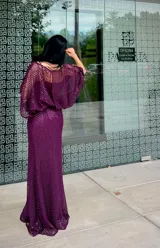 Vestido largo de fiesta color gris, confeccionado en tejido con textura calada tipo red. Presenta un diseño de silueta fluida con mangas amplias tipo murciélago y escote redondo.