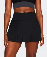 Minifalda plisada de corte deportivo color negro, con cintura alta elastizada y shorts incorporados.