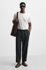 Sandalia de cuero negra con dos tiras anchas en el empeine y tira para el dedo gordo.