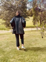 Gamulan de cuero negro con cuello, puños y ruedo de piel sintética negra.