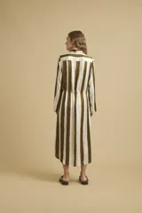 Vestido camisero largo con rayas verticales color marrón y blanco, de corte recto y manga larga. Tiene cuello camisero, cierre frontal con botones y cordón ajustable en la cintura.