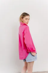 Camisa fucsia de algodón, corte clásico, manga larga y cierre con botones.