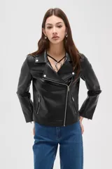 Campera estilo biker de cuero sintético color negro, con cierre frontal cruzado, solapas con botones a presión y bolsillos laterales con cierre.