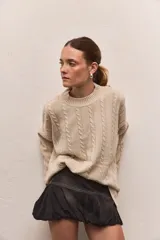 Buzo tejido color borgoña con cuello redondo y diseño de trenzas verticales.