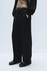 Pantalón de punto de tiro alto con bolsillos delanteros y bolsillos de plastrón en la parte trasera. Presenta una cintura doble ajustable con cordón en tejido a contraste.