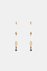 Pack de tres pares de pendientes dorados que incluye dos pares de aros de diferentes tamaños y un par de pendientes con dije de placa ovalada y cristales negros colgantes.