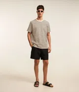 Bermuda boardshort negra de microfibra, con cintura elástica y cordón ajustable. Incluye bolsillos laterales y está confeccionada con poliéster certificado RCS.