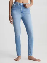 Jean skinny de tiro alto Calvin Klein, color celeste, con bolsillos delanteros y traseros, cierre con cremallera y botón, y etiqueta de cuero con logo en la parte trasera.