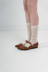 Chatas rojas de charol con punta fina y tiras con hebillas y ojalillos.