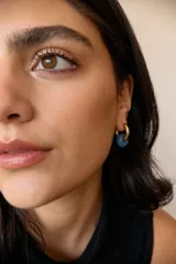 Aros dorados con dije circular de piedra natural negra.