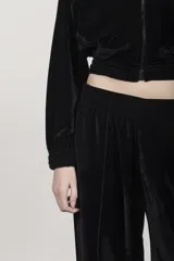 Campera negra de terciopelo con capucha doble, cierre frontal, dos bolsillos y frunce en puños y cintura.