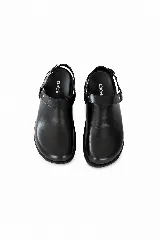 Zueco destalonado tipo slingback de napa negra, con tira ajustable en el talón, hebilla metálica y argolla lateral decorativa con tachas.