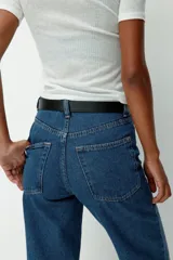 Jean de tiro alto confeccionado en denim rígido, con diseño de cinco bolsillos, cierre con botón y corte de pierna recta levemente holgado.