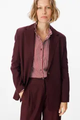 Blazer de corte sastrero en color bordó, con solapas clásicas, cierre frontal de un botón y diseño de hombros estructurados.